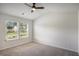 Bedroom with neutral carpet, ceiling fan and view to the exterior at 953 Mystic Way, Hampton, GA 30228