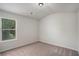 Bedroom with neutral carpet, ceiling light and a view to the wooded exterior at 953 Mystic Way, Hampton, GA 30228