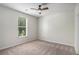 Bedroom with neutral carpet, ceiling fan, and a view to the wooded exterior at 953 Mystic Way, Hampton, GA 30228