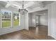 Dining room featuring coffered ceiling, a modern chandelier, and large windows at 953 Mystic Way, Hampton, GA 30228