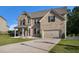 Lovely two-story brick home with a neat lawn, two-car garage, and welcoming front porch at 953 Mystic Way, Hampton, GA 30228