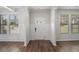 Bright foyer with hardwood floors, white wainscoting, and a front door with glass inserts at 953 Mystic Way, Hampton, GA 30228