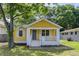 Charming yellow bungalow with a welcoming front porch and well-maintained lawn and trees at 103 Chicamauga Sw Ave, Atlanta, GA 30314