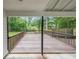 View of a covered wooden deck with wooden railings and black supports overlooking a wooded lot at 1192 Sandalwood Dr, Lawrenceville, GA 30043
