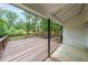 View of a covered wooden deck with wooden railings and black supports overlooking a wooded lot at 1192 Sandalwood Dr, Lawrenceville, GA 30043