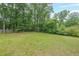 View of a expansive green backyard with tall trees and greenery at 1192 Sandalwood Dr, Lawrenceville, GA 30043