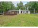 Exterior back view of the home with a wooden deck overlooking the backyard and wooded area at 1192 Sandalwood Dr, Lawrenceville, GA 30043