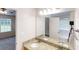 Bathroom showcasing a granite countertop vanity, dual sinks, and an open view to the bedroom at 150 Mills Creek Ln, Covington, GA 30016