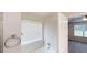 Clean bathroom with a bathtub, shower, window with blinds, and neutral decor at 150 Mills Creek Ln, Covington, GA 30016