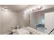 Well-lit bathroom featuring a double vanity, large mirror, tub, and modern fixtures at 2530 Flippen Rd, Stockbridge, GA 30281