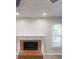 Living room featuring a brick fireplace with mantel and hearth, plus wood-look floors and a window at 2530 Flippen Rd, Stockbridge, GA 30281