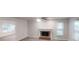 Open-concept living room featuring a brick fireplace, ceiling fan, and large windows at 2530 Flippen Rd, Stockbridge, GA 30281