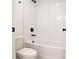 White subway tiled bathtub and toilet with black fixtures at 2732 Eagles Crest Ln, Decatur, GA 30034