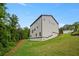 Backyard view of two-story home with gray siding, lawn, and greenery against a blue sky at 2732 Eagles Crest Ln, Decatur, GA 30034