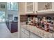 Wet bar area with granite countertop, backsplash, wine rack and view of the living room at 3783 Wickford Ln, Peachtree Corners, GA 30096