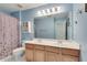 Well-lit bathroom with a double sink vanity, and a shower with a patterned curtain at 3783 Wickford Ln, Peachtree Corners, GA 30096