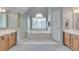 Main bathroom featuring a glass shower, soaking tub, and dual sinks with wood cabinets at 3783 Wickford Ln, Peachtree Corners, GA 30096