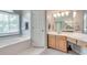 Bathroom features a soaking tub beneath a window plus a vanity area with wooden cabinets at 3783 Wickford Ln, Peachtree Corners, GA 30096