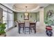 Formal dining room featuring a tray ceiling, elegant lighting, and a large window at 3783 Wickford Ln, Peachtree Corners, GA 30096