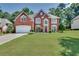 Traditional brick home featuring a two-car garage, well-maintained lawn, and inviting curb appeal at 3783 Wickford Ln, Peachtree Corners, GA 30096
