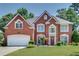 Traditional brick home with a two-car garage, lush lawn, and a charming, landscaped front yard at 3783 Wickford Ln, Peachtree Corners, GA 30096