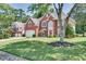 Traditional brick home with attached garage, lush lawn, and mature trees offering a welcoming curb appeal at 3783 Wickford Ln, Peachtree Corners, GA 30096