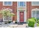 Close-up of a charming front entrance with a red door, decorative wreath, and manicured landscaping at 3783 Wickford Ln, Peachtree Corners, GA 30096