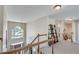 Upstairs hallway with bookshelves and staircase overlooking the bright foyer with windows at 3783 Wickford Ln, Peachtree Corners, GA 30096
