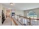 Upstairs hallway overlooking the foyer with large windows and view of the living room fireplace at 3783 Wickford Ln, Peachtree Corners, GA 30096