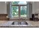 Close up of stainless steel sink overlooking the backyard with granite countertops at 3783 Wickford Ln, Peachtree Corners, GA 30096