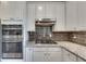 Close up of the kitchen with stainless steel double oven, gas cooktop, and granite countertops at 3783 Wickford Ln, Peachtree Corners, GA 30096