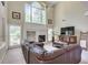 Bright, airy living room with fireplace, large windows, high ceilings, and a comfortable leather sofa at 3783 Wickford Ln, Peachtree Corners, GA 30096