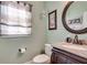 Charming powder room featuring a granite vanity, oval mirror, and stylish fixtures at 3783 Wickford Ln, Peachtree Corners, GA 30096