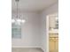 Dining room with chandelier lighting, carpet, and view into the kitchen and yard at 765 Stonebridge Run, Lithonia, GA 30058