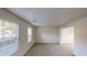 Spacious living room with carpeted floors, neutral paint, and two bright windows at 765 Stonebridge Run, Lithonia, GA 30058