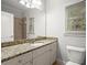 Well-lit bathroom with a granite countertop, large mirror, and a view of the outdoors at 980 Pine Grove Rd, Roswell, GA 30075