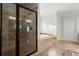 Elegant bathroom features a glass enclosed shower with dual shower heads and separate soaking tub at 980 Pine Grove Rd, Roswell, GA 30075