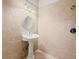 Elegant bathroom featuring a pedestal sink, decorative mirror, and neutral tile at 980 Pine Grove Rd, Roswell, GA 30075