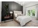 A serene bedroom boasts a stylish chandelier, a large window with great lighting and dark accent wall at 980 Pine Grove Rd, Roswell, GA 30075