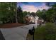 Long private driveway leading to a beautiful brick home surrounded by lush greenery and mature trees at 980 Pine Grove Rd, Roswell, GA 30075