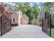Long concrete driveway leading to a two-car garage behind an ornate gate at 980 Pine Grove Rd, Roswell, GA 30075