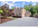 Side view of home featuring driveway leading to garage and side yard trees at 980 Pine Grove Rd, Roswell, GA 30075
