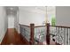 Bright hallway showcasing hardwood floors, decorative railing, chandelier and a view of the outdoors at 980 Pine Grove Rd, Roswell, GA 30075