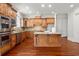 Kitchen features dark wood cabinets, granite countertops, stainless appliances, and large island at 980 Pine Grove Rd, Roswell, GA 30075
