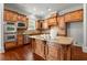 Kitchen features dark wood cabinets, granite countertops, stainless appliances, and large island at 980 Pine Grove Rd, Roswell, GA 30075