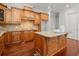A kitchen features an island and gorgeous brown cabinetry and matching hardwood floors at 980 Pine Grove Rd, Roswell, GA 30075
