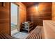 Wood-lined sauna featuring tiered benches, rock heater, and view into the hot tub room at 980 Pine Grove Rd, Roswell, GA 30075