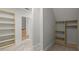 Large walk-in closet with built-in shelves and access to a stylish bathroom with a soaking tub at 980 Pine Grove Rd, Roswell, GA 30075