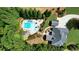 Expansive aerial view of a private backyard featuring a luxurious pool, surrounded by lush greenery, and an outdoor seating area at 102 Cavit Ct, Canton, GA 30114