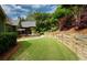 Spacious backyard with lush green lawn, mature landscaping, and retaining wall at 102 Cavit Ct, Canton, GA 30114